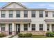 Exterior view of townhome with white siding, stone accents and covered entryways, reflecting modern design at 7812 Park Gate Dr, North Charleston, SC 29418
