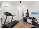 Exercise room with treadmill and exercise bike in a well lit space with wood floors and white walls at 8604 Bowen Corner Ave, Hanahan, SC 29410