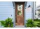 Close-up of a charming wooden front door with a wreath, enhancing the home's curb appeal and inviting guests at 8604 Bowen Corner Ave, Hanahan, SC 29410