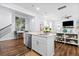Kitchen featuring island with sink, dishwasher and white cabinetry that opens into a sitting area with artwork at 8604 Bowen Corner Ave, Hanahan, SC 29410