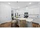 Bright kitchen features white cabinets, stainless steel appliances, and pendant lighting over a quartz countertop island at 8604 Bowen Corner Ave, Hanahan, SC 29410