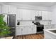 Close up of a white kitchen featuring stainless steel appliances, white cabinets, and wood flooring at 8604 Bowen Corner Ave, Hanahan, SC 29410