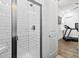 Modern shower with white subway tile and glass door, next to a room with a treadmill at 8604 Bowen Corner Ave, Hanahan, SC 29410