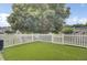 An inviting backyard featuring well-maintained artificial grass, a white picket fence, and a lush green tree offering plenty of shade at 1005 Washitonia Way # B, Charleston, SC 29492