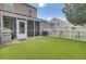 A well-kept backyard boasts artificial grass, a white picket fence, screened-in porch, and a patio area perfect for outdoor entertaining at 1005 Washitonia Way # B, Charleston, SC 29492