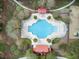 Aerial view of a community pool surrounded by lounge chairs, palm trees, and red-roofed cabanas, offering a luxurious resort-style experience at 1005 Washitonia Way # B, Charleston, SC 29492