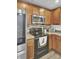 Modern kitchen with stainless steel appliances and wood cabinets against a brick backsplash at 1005 Washitonia Way # B, Charleston, SC 29492
