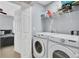 Bright laundry room with white washer and dryer, as well as shelving for storage at 1005 Washitonia Way # B, Charleston, SC 29492