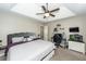 Well-lit bedroom featuring a tray ceiling, desk, wall-mounted television, and a cozy ambiance at 102 Jasimine Ct, Summerville, SC 29486