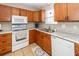 Kitchen featuring wood cabinets, white appliances, tile floors, and granite countertops at 102 Jasimine Ct, Summerville, SC 29486