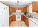 Kitchen with wooden cabinetry, tile floors, white appliances, and granite countertops at 102 Jasimine Ct, Summerville, SC 29486