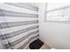 Cozy shower with a white and gray striped curtain and a small window with blinds at 102 Jasimine Ct, Summerville, SC 29486