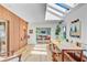 Bright dining room with skylights, wood floors, wood accent wall, and open flow to the living room at 11 Francis St, Charleston, SC 29403
