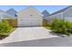 Two-car garage with a concrete driveway and well-manicured landscaping at 112 Crimson St, Summerville, SC 29486