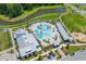 Aerial view of a community pool with several people in the pool and a view of a pond and wooded area at 112 Crimson St, Summerville, SC 29486