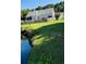 Relaxing backyard featuring a home with porch and fence, near tranquil pond with lush lawn at 114 Sea Cotton Cir, Charleston, SC 29412