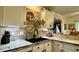 Stylish kitchen sink with black faucet, mosaic backsplash, and elegant white cabinets offers contemporary convenience at 114 Sea Cotton Cir, Charleston, SC 29412