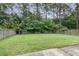 Lush backyard enclosed by a wooden fence, featuring a well-maintained lawn and mature trees at 125 Towering Pine Dr, Ladson, SC 29456