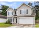 Two-story home with large front windows, a two-car garage, and a well-kept lawn at 125 Towering Pine Dr, Ladson, SC 29456
