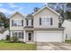 Charming two-story home with a well-maintained lawn, blue shutters, and a two-car garage at 125 Towering Pine Dr, Ladson, SC 29456