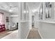 Bright hallway leads to a bedroom with neutral walls and chair, creating a cozy and inviting space at 125 Towering Pine Dr, Ladson, SC 29456