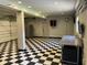 Well-lit garage interior with checkered floors, refrigerator, wall cabinets, and garage door openers at 1298 French Santee Rd, Jamestown, SC 29453