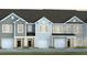 Charming townhome featuring multiple units with attached garages and landscaped front yards at 136 Yarrow Way, Moncks Corner, SC 29461