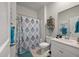 Well-lit bathroom with a shower, patterned shower curtain, white cabinets, and essential fixtures at 143 Daniels Creek Cir, Goose Creek, SC 29445