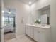 Bathroom with double sinks, white cabinetry, and a view into the adjacent main bedroom at 143 Daniels Creek Cir, Goose Creek, SC 29445