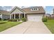 Charming brick home featuring a two-car garage, manicured landscaping, and a cozy front porch at 143 Daniels Creek Cir, Goose Creek, SC 29445