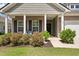 Close-up of the front porch area with brick facade and lush landscaping at 143 Daniels Creek Cir, Goose Creek, SC 29445