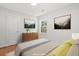Stylishly staged bedroom with natural light, wood floors, and tastefully decorated with modern artwork at 1430 E Montague Ave, North Charleston, SC 29405