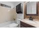 Well-lit bathroom with a single sink vanity, tiled shower and bathtub combination, and dark brown accents at 1593 Westwood Dr, Charleston, SC 29412