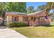 Cozy home featuring brick accents, solar panels, and a charming covered front porch at 1593 Westwood Dr, Charleston, SC 29412