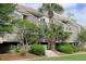Exterior view of the townhouse with landscaping and multiple levels of balconies at 1634 Live Oak Park, Seabrook Island, SC 29455