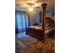 Bedroom featuring a four-poster bed, wood-look floors, and natural light from the nearby window at 1671 Dawson Branch Rd, Summerville, SC 29483