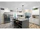 Modern kitchen features stainless steel appliances, island with seating and elegant white cabinets at 1671 Dawson Branch Rd, Summerville, SC 29483