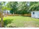 Large, well-kept backyard with lush green grass, a wooden fence, shed and dog house, ideal for outdoor enjoyment at 1703 Dotterers Run, Charleston, SC 29414