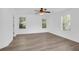 Bright bedroom with wood-look flooring, a ceiling fan, and white walls, enhanced by natural light from three windows at 1703 Dotterers Run, Charleston, SC 29414