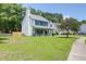 Lovely 2-story home with an attached garage, flowering tree, and expansive lawn at 1703 Dotterers Run, Charleston, SC 29414