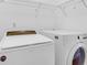 Bright laundry room features a white washer and dryer with shelving for storage at 1703 Dotterers Run, Charleston, SC 29414