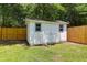 Well-maintained backyard shed with white paint, green trim and classic double door design on a lush green lawn at 1703 Dotterers Run, Charleston, SC 29414