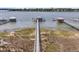 Aerial view showcases long wooden docks extending over marsh to covered pier heads, offering boating access at 1720 Bowline Dr, Mount Pleasant, SC 29466