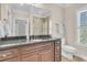 Bathroom featuring dark wood cabinets, stone countertops, and a window with shutters at 1720 Bowline Dr, Mount Pleasant, SC 29466