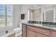 Bathroom featuring dark wood cabinets, stone countertops, and a window with shutters at 1720 Bowline Dr, Mount Pleasant, SC 29466