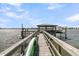 Close up of dock featuring a covered pier head, with a boat lift, kayak and water views under a blue sky at 1720 Bowline Dr, Mount Pleasant, SC 29466
