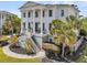 Elegant two-story home boasts grand columns, black trim, and a welcoming front porch with rocking chairs at 1720 Bowline Dr, Mount Pleasant, SC 29466