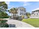 Elegant two-story home boasts grand columns, black trim, and a welcoming front porch with rocking chairs at 1720 Bowline Dr, Mount Pleasant, SC 29466