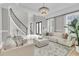Bright living room with a stunning chandelier, a staircase, and large windows with natural light at 1720 Bowline Dr, Mount Pleasant, SC 29466