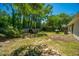 Spacious backyard with a grill, mature trees, and partially fenced at 2016 Wild Flower Ln, Charleston, SC 29414